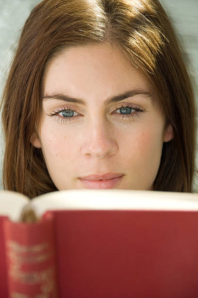 Cute young woman reading a book