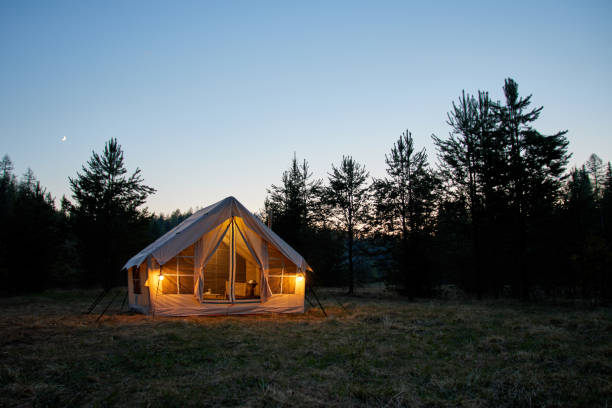 istock Large camping tent in a natural setting at sunset. Warm cozy light inside a camping tent. 1811393837