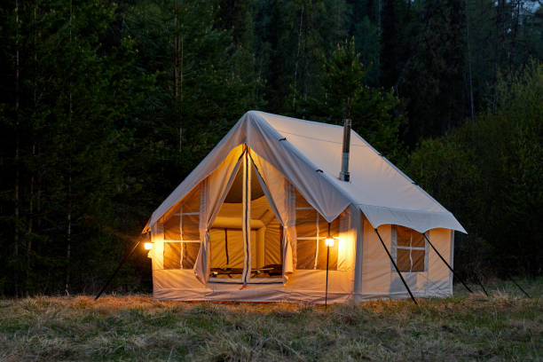 istock Large camping tent in a natural setting at sunset. Warm cozy light inside a camping tent. 1811393839