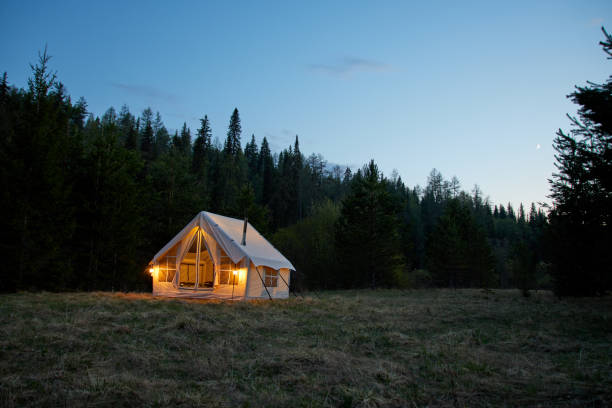 istock Large camping tent in a natural setting at sunset. Warm cozy light inside a camping tent. 1811393851