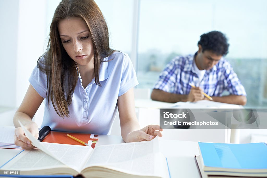 Girl at exam Student girl using dictionary at an exam 20-24 Years Stock Photo
