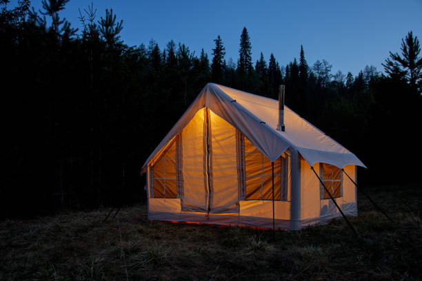 istock Large camping tent in a natural setting at sunset. Warm cozy light inside a camping tent. 1811398287