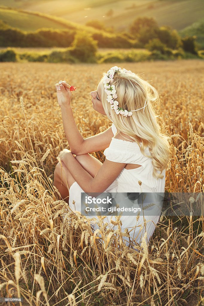 Beautiful lonely blonde enjoying the nature Beautiful young woman sitting in wheat and enjoy Adult Stock Photo
