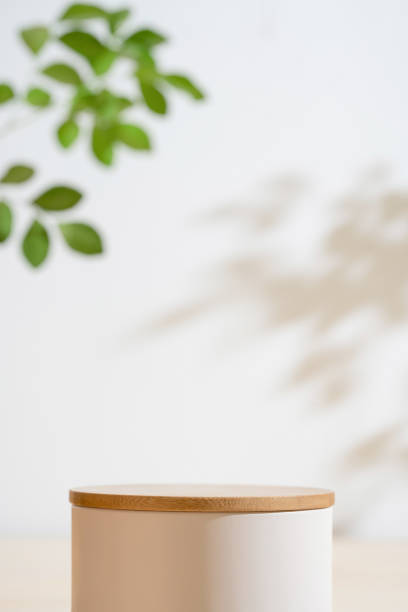 分離型背景に最小限の木の白い表彰台とぼかした緑の葉の植物。美容化粧品ナチュラルマイルド製品のモダンなディスプレイ、自然の環境に優しいコンセプト。 - table counter top wood isolated ストックフォトと画像