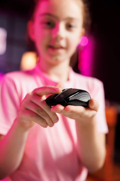 Cheerful kid filming electronics haul, testing scrolling wheel on wired gaming mouse, close up
