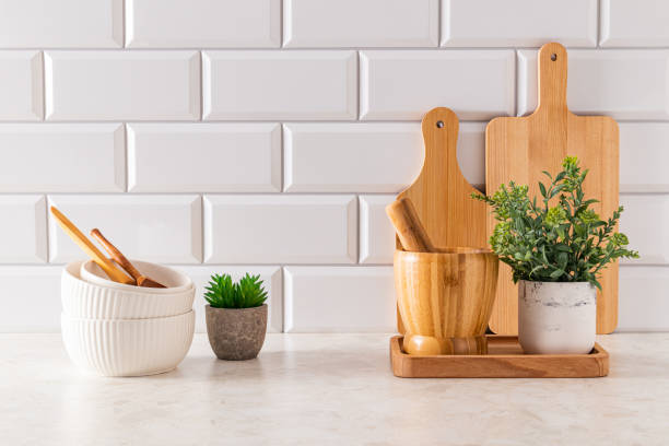 istock Set of ceramic bowls and cutting boards on stone light countertop in modern kitchen with potted, cactus . Front view. minimalism. 1811416470
