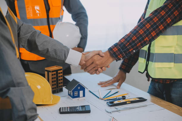 istock Construction and structure concept of Engineer or architect meeting for project working with partner and engineering tools on model building and blueprint in working site, contract for both companies. 1811419393