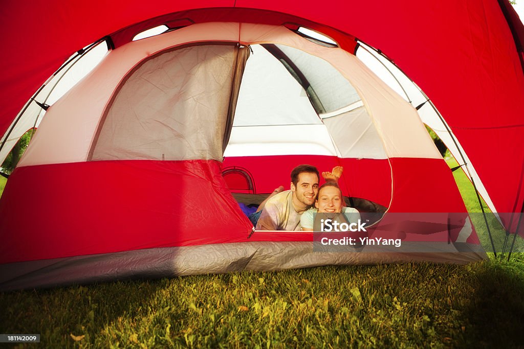 Giovane Coppia all'interno di un grande tenda rossa godendo all'aperto e campeggio - Foto stock royalty-free di Abbracciare una persona