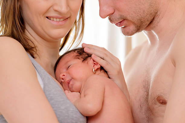 family baby girl in his parents hands. half dressed girls pictures stock pictures, royalty-free photos & images