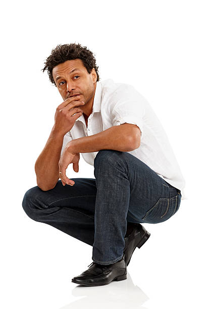 istock Thoughtful man crouching on floor looking away 181142548