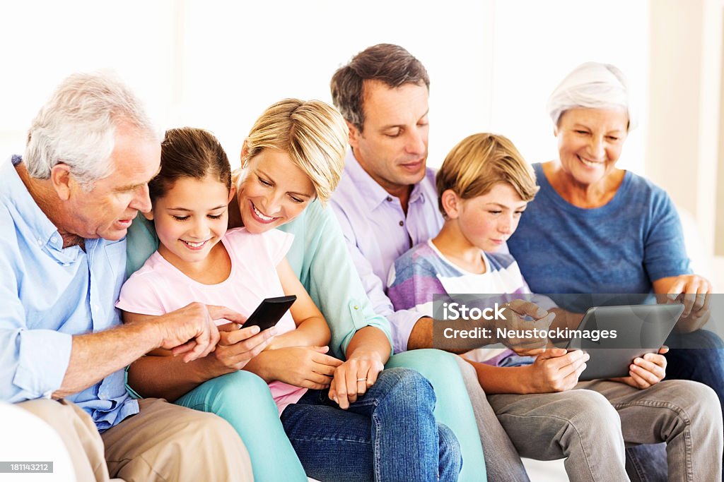 Trzy pokolenia rodziny za pomocą Inteligentny telefon i Tablet - Zbiór zdjęć royalty-free (Rodzina wielopokoleniowa)
