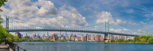 RFK Triborough Bridge and New York City Skyline with Skyscrapers of Manhattan Upper East Side in the Morning, New York, USA. High resolution stitched panorama of the Robert F Kennedy (RFK) Triborough Bridge with Water of East River and Skyscrapers of Manhattan Upper East Side in Background on a Cloudy Morning as seen from Astoria Park, Queens, New York, USA. Canon EOS 6D (Full Frame censor) DSLR. Canon EF 85mm f/1.8 USM Prime Lens. 3:1 Image Aspect Ratio. This image was downsized to 50MP. Original image resolution is 91MP or 16500 x 5500px. harlem park stock pictures, royalty-free photos & images