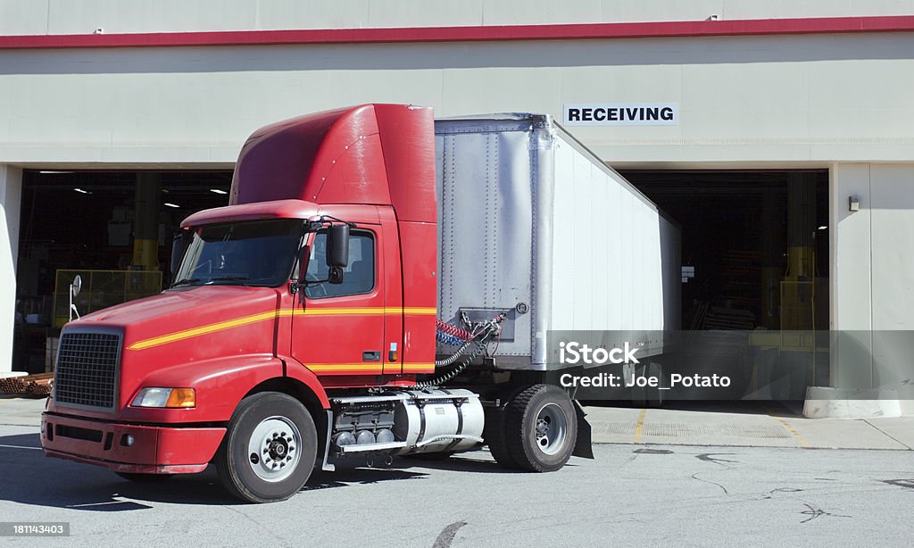 Semi Trailer Red and Yellow semi cab and trailer at warehouse loading dock. Horizontal. Loading Dock Stock Photo