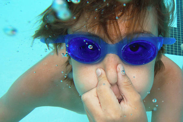 istock Young Boy Underwater Pinching Nose 181143923