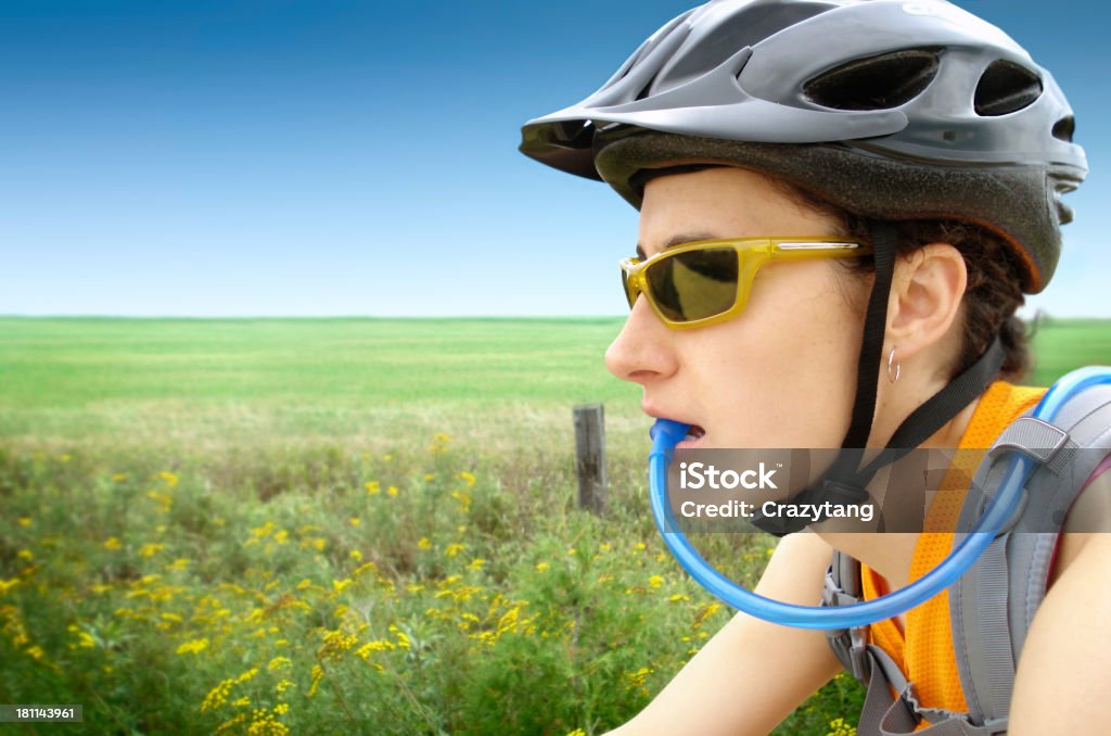 Giovane donna con casco da bici) e acqua potabile - Foto stock royalty-free di Adulto