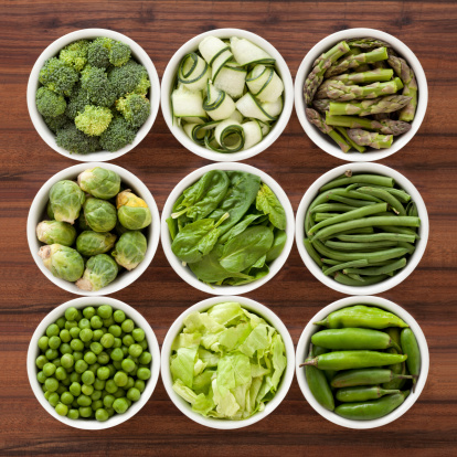 Nine bowls containing varieties of green vegetables