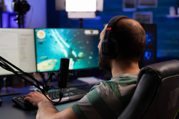 istock Concentrated gamer playing shooter game 1811444730