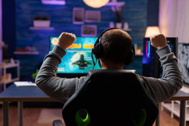 istock Back view of happy gamer playing and winning 1811445157
