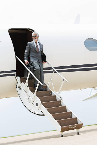 istock Professional businessman on steps of private jet 181144877