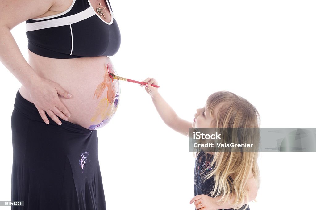 Niña concentrarse en pintura en la parte superior de la madre del vientre. - Foto de stock de 2-3 años libre de derechos