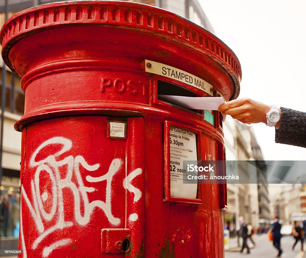 Mano donna di registrazione lettere in inglese britannico tradizionale cassetta postale - Foto stock royalty-free di Adulto