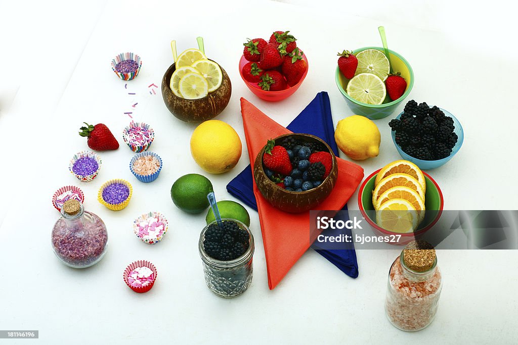 Fruit Snacks "bowls of fruit with variety of colored sugars to dip in lemon, lime, strawberry, blueberry, blackberry, orange" Arranging Stock Photo