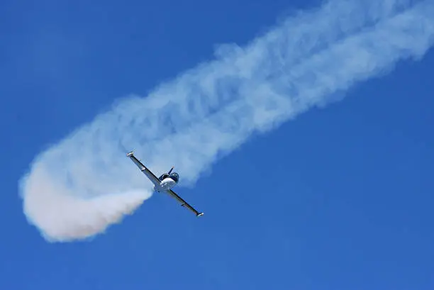 Jet stunt plane at an airshow with smoke trail, coming towards the camera