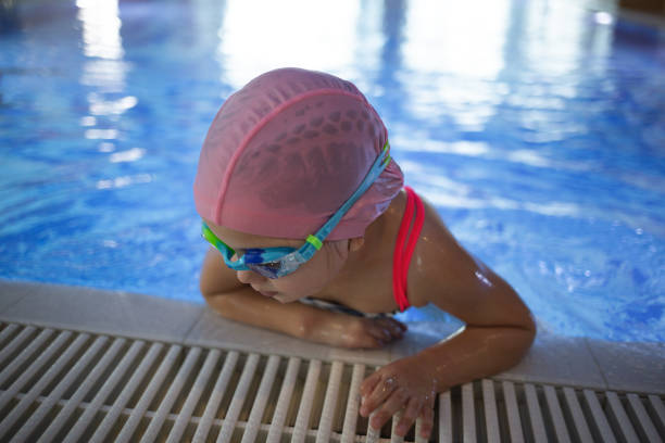 istock little cute girl performs exercises at the training in the pool 1811464767