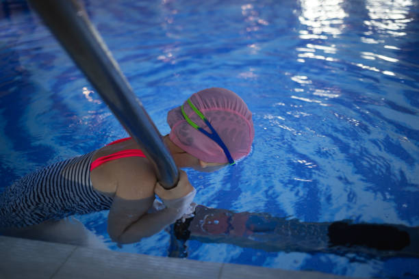 istock little cute girl performs exercises at the training in the pool 1811464768