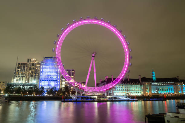 London, England - November 22, 2023: Night has descended upon London, and across the Thames we see the colourfully-lit London Eye, one of the biggest tourist attractions in the English capital. This great Ferris wheel/cantilevered observation wheel on the banks of the Thames was built in 1999, and is the tallest in Europe.