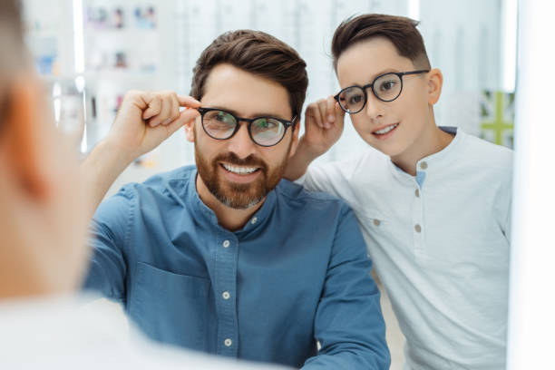 istock Happy father and son choosing eyeglasses frames in optical shop 1811471901