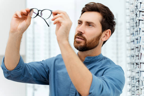 istock Focused man holding new glasses in optics 1811471940