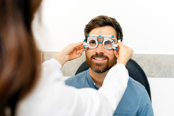 istock Oculist and smiling young man with trial frame in optic shop 1811472482