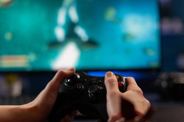 istock Close up of gamer holding controller and playing video games 1811472537