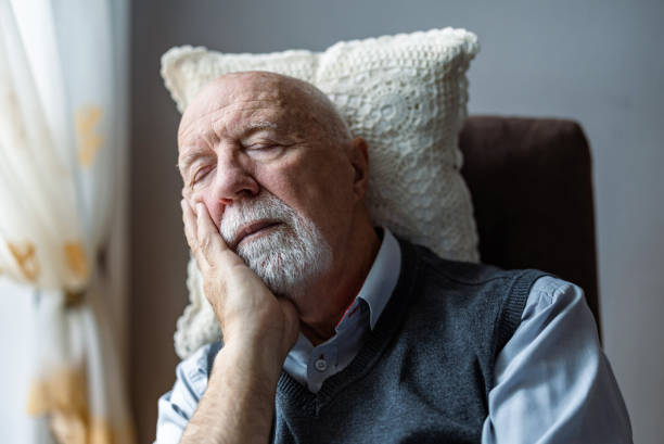 Senior man sleeping in an armchair at home