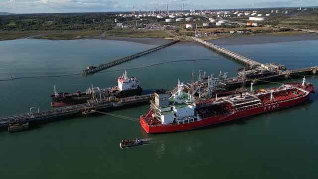 Fawley oil terminal with red oil tanker and support boat aerial