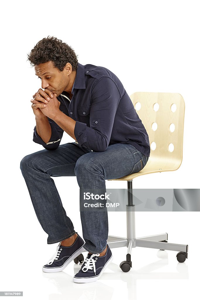 Mature man sitting on chair looking sad Mature man sitting on chair looking sad over white background Sadness Stock Photo