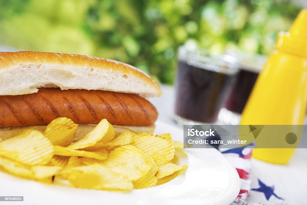 Hot dog auf einem Tisch im Freien in helles Licht - Lizenzfrei Kartoffelchips Stock-Foto