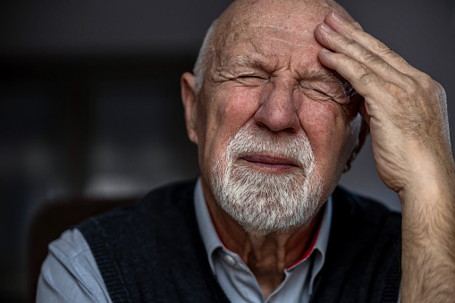 Portrait of a senior man suffering from a headache