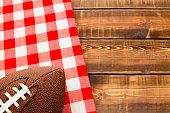 Football over a red and white cloth on a wooden table