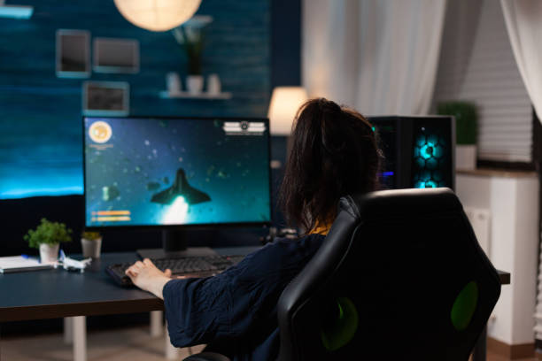 istock Woman using keyboard to play online video games 1811488877