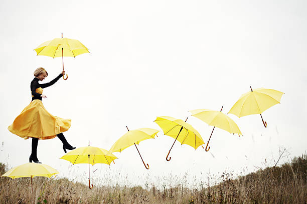 秋の夢 - umbrella women storm yellow ストックフォトと画像