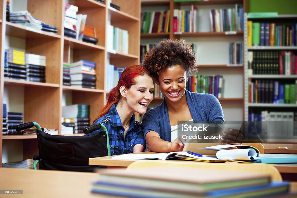 Alunos usando tablet digital na biblioteca - Foto de stock de Biblioteca royalty-free