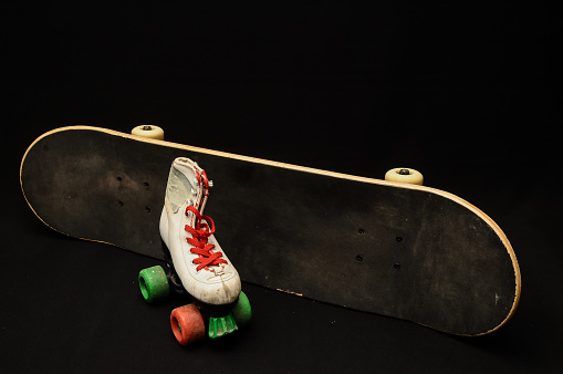 Vintage Style Black Skateboard and Skate Boot on a Dark Background