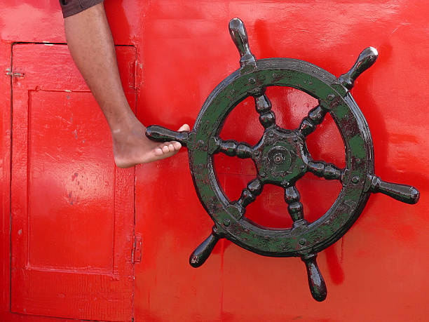 istock ship steering wheel on red with foot 181150312