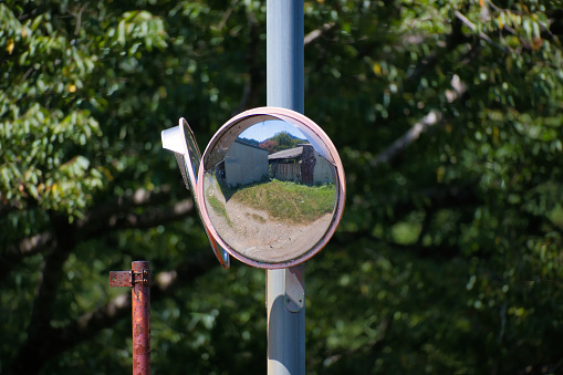 Curved mirror installed at an intersection on a country road