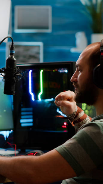 istock Streamer man talking with multiple players into headphones winning 1811508162