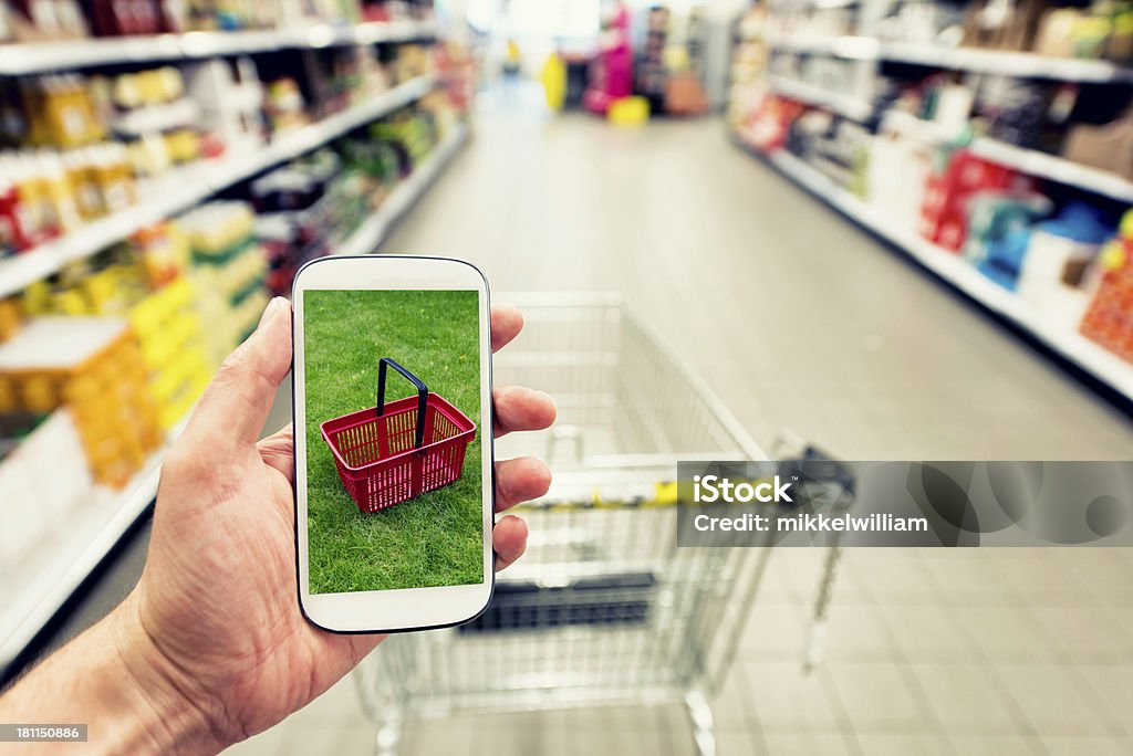 Zakupy w supermarked z smartphone - Zbiór zdjęć royalty-free (Pokazywać)