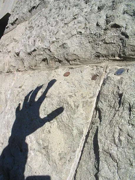 Gollum's hand shadow while it tries to climb on the rock and grab a few precious coins