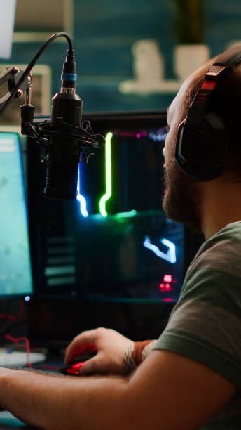 istock Over shoulder footage of professional streamer with headset playing 1811514701